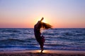 Girl jumping on the sea coast at sunrise Royalty Free Stock Photo