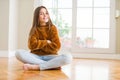 Beautiful young girl kid sitting on the floor at home happy face smiling with crossed arms looking at the camera Royalty Free Stock Photo