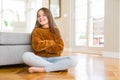 Beautiful young girl kid sitting on the floor at home happy face smiling with crossed arms looking at the camera Royalty Free Stock Photo