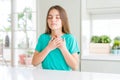 Beautiful young girl kid wearing green t-shirt smiling with hands on chest with closed eyes and grateful gesture on face Royalty Free Stock Photo