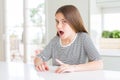 Beautiful young girl kid wearing stripes t-shirt afraid and shocked with surprise expression, fear and excited face Royalty Free Stock Photo