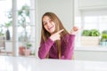 Beautiful young girl kid on white table smiling and looking at the camera pointing with two hands and fingers to the side Royalty Free Stock Photo