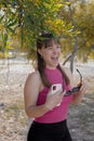 Beautiful young girl laughing and stands in the garden of mimosa trees blooming with yellow flower Royalty Free Stock Photo