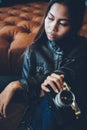 Beautiful young girl in leather jacket holding camera