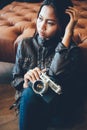 Beautiful young girl in leather jacket holding camera