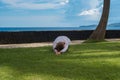 Beautiful young girl in leggings and tunic makes yoga practice, meditation asana on the ocean beach Bali Indonesia Royalty Free Stock Photo