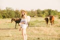 A beautiful young girl, with light curly hair in a straw hat near horses, in the countryside, warm autumn Royalty Free Stock Photo