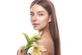 Beautiful young girl with a light natural make-up and perfect skin with flowers in her hand . Beauty face. Royalty Free Stock Photo