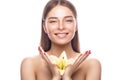 Beautiful young girl with a light natural make-up and perfect skin with flowers in her hand . Beauty face. Royalty Free Stock Photo