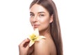 Beautiful young girl with a light natural make-up and perfect skin with flowers in her hand . Beauty face. Royalty Free Stock Photo