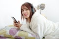 Beautiful young girl listening to music in her bed Royalty Free Stock Photo