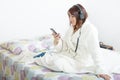 Beautiful young girl listening to music in her bed Royalty Free Stock Photo