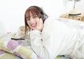 Beautiful young girl listening to music in her bed Royalty Free Stock Photo