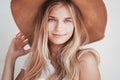 Beautiful young girl with long blond hair and blue eyes in a hat, closeup portrait Royalty Free Stock Photo