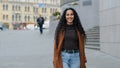 Beautiful young girl with long dark hair hispanic woman female model stands on street in city walking looking at camera Royalty Free Stock Photo