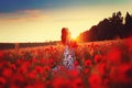 A beautiful young girl in a long dress stands in a poppy field. Royalty Free Stock Photo