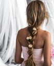 Beautiful young girl with long hair flowers the tenderness of the mystery in a braid steed back Royalty Free Stock Photo