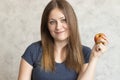 Beautiful young girl with long hair holding a red apple in her hand. Portrait of a beautiful woman with a cute smile. Healthy food Royalty Free Stock Photo