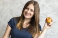 Beautiful young girl with long hair holding a red apple in her hand. Portrait of a beautiful woman with a cute smile. Healthy food Royalty Free Stock Photo