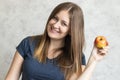 Beautiful young girl with long hair holding a red apple in her hand. Portrait of a beautiful woman with a cute smile. Healthy food Royalty Free Stock Photo