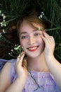 Beautiful young girl with long red curly hair. Girl with closed eyes lies on the green grass. view from above. Royalty Free Stock Photo