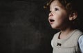 Beautiful young girl looking away against a dark moody background Royalty Free Stock Photo