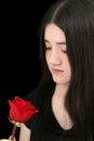 Beautiful Young Girl Looking At Red Rose Against Black Royalty Free Stock Photo