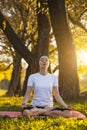 Beautiful young girl meditating in autumn park Royalty Free Stock Photo