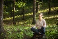 Beautiful woman meditating in the forest on a sunny morning Royalty Free Stock Photo