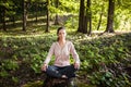 Beautiful woman meditating in the forest on a sunny morning Royalty Free Stock Photo