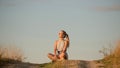 Beautiful young girl meditating on the hill in the rays of the setting sun Royalty Free Stock Photo