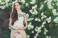 Beautiful young girl model posing near blooming lilacs at spring Royalty Free Stock Photo