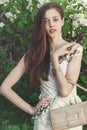 Beautiful young girl model posing near blooming lilacs at spring Royalty Free Stock Photo