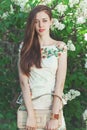 Beautiful young girl model posing near blooming lilacs at spring Royalty Free Stock Photo