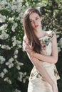 Beautiful young girl model posing near blooming lilacs at spring Royalty Free Stock Photo