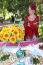 Beautiful young girl in the national Ukrainian costume presents national alcoholic drink.