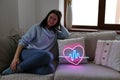 Beautiful young  girl with neon signs. Neon sign pink heart. Trendy style. Valentine day Royalty Free Stock Photo