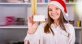 Beautiful young girl office manager in the company smiling wearing the Santa cap having the badge on her white shirt and Royalty Free Stock Photo