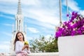 Beautiful young girl on the Ortiz Bridge eating a mango. On background the famous gothic church of La Ermita built on 1602 in the Royalty Free Stock Photo