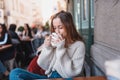 Beautiful young girl in outdoor cafe drinks coffee Royalty Free Stock Photo