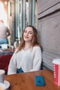 Beautiful young girl in outdoor cafe smiles Royalty Free Stock Photo