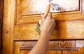 Beautiful young girl paints a wooden door. Summer work in the garden