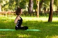 Beautiful young girl in park practices yoga and relaxes. Calm and tranquility