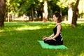 Beautiful young girl in park practices yoga and relaxes. Calm and tranquility Royalty Free Stock Photo