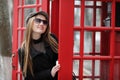 Beautiful young girl in a phone booth. The girl is talking on th Royalty Free Stock Photo