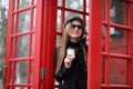 Beautiful young girl in a phone booth. The girl is talking on th Royalty Free Stock Photo