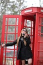 Beautiful young girl in a phone booth. The girl is talking on th Royalty Free Stock Photo