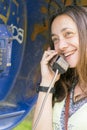 Beautiful young girl in a phone booth. The girl is talking on the phone from the payphone. pretty teen girl talking by public Royalty Free Stock Photo