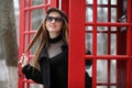 Beautiful young girl in a phone booth. The girl is talking on th Royalty Free Stock Photo