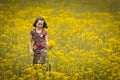 Beautiful young girl picking flowers in a field